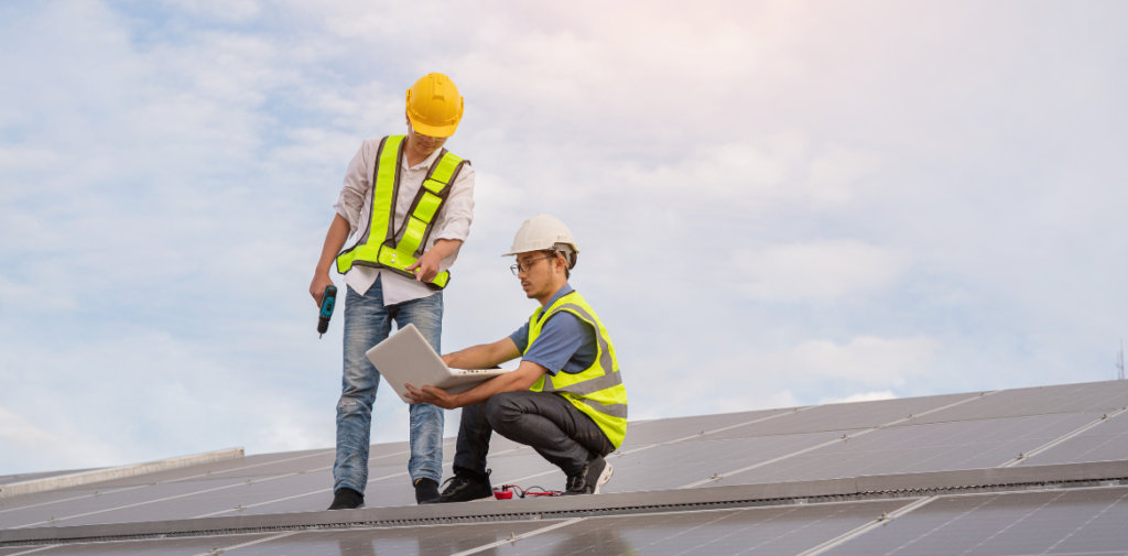 Two service workers on a rooftop looking at their clipboard